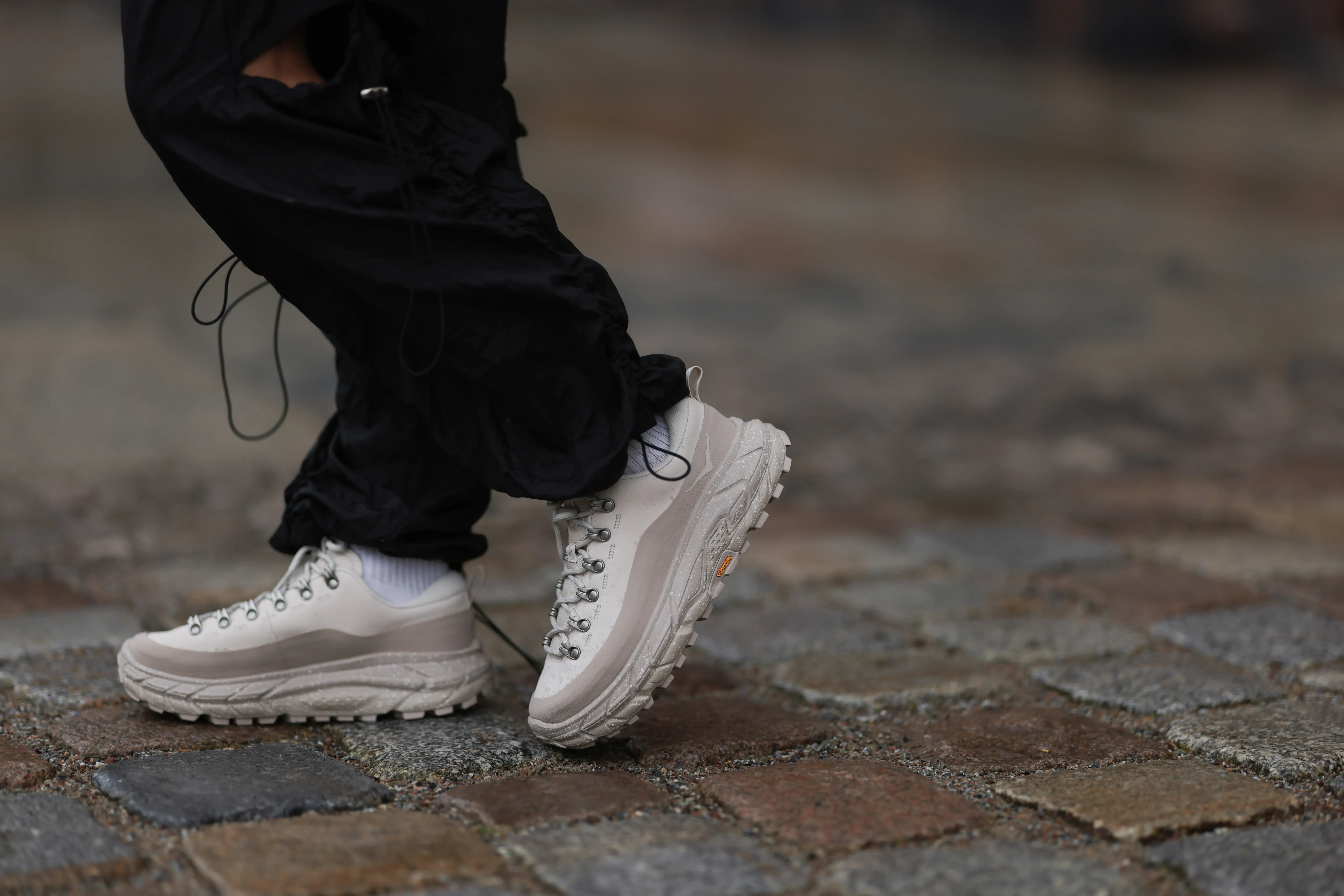 Madina Katter seen wearing black nylon cargo pants, white cotton socks and Hoka Tor Summit oat milk / oxford tan sneakers, on January 26, 2024 in Berlin, Germany.