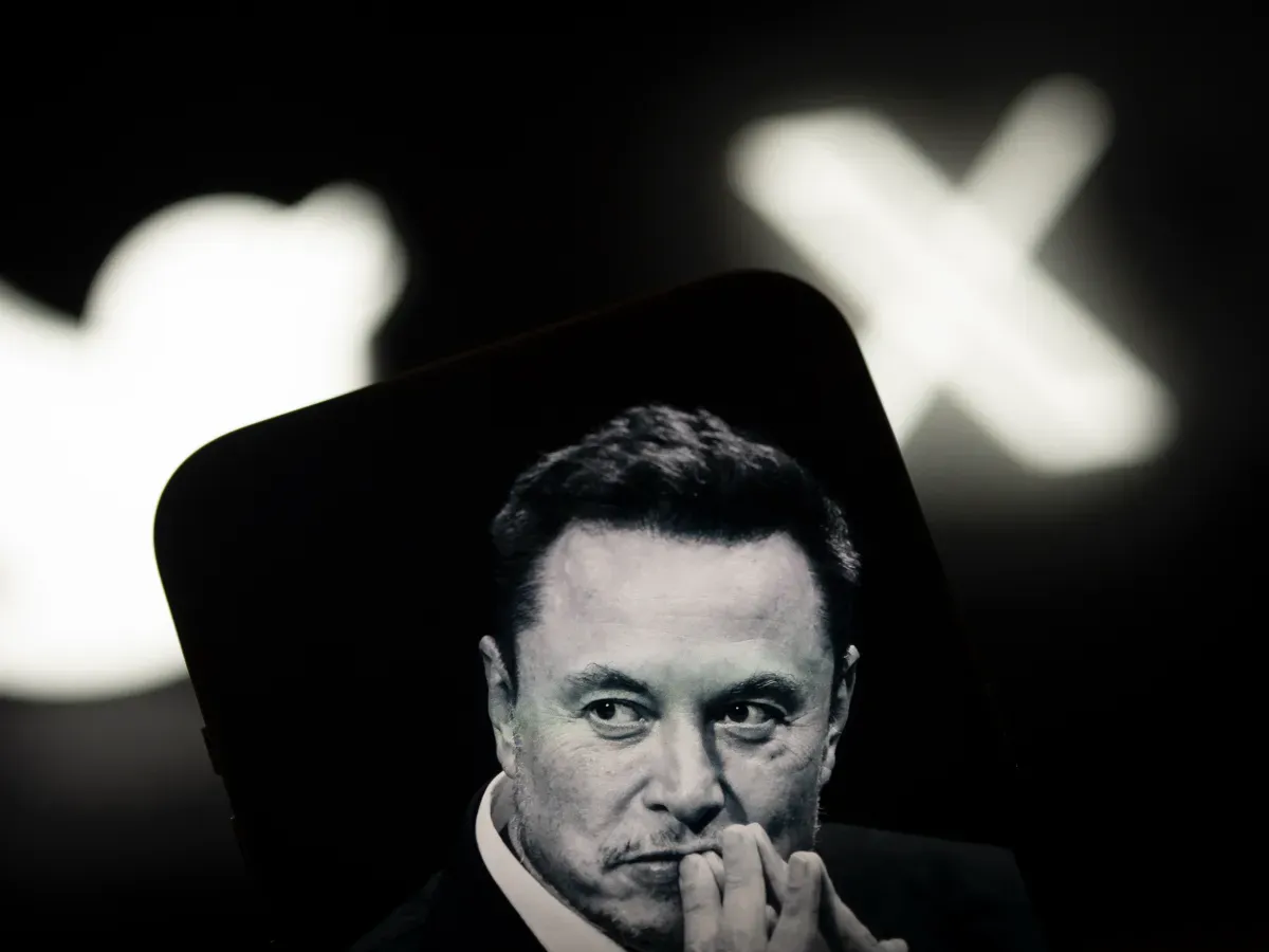 An image of Elon Musk is seen displayed on a mobile device with the X logo in background. (Photo by Jaap Arriens/NurPhoto via Getty Images)