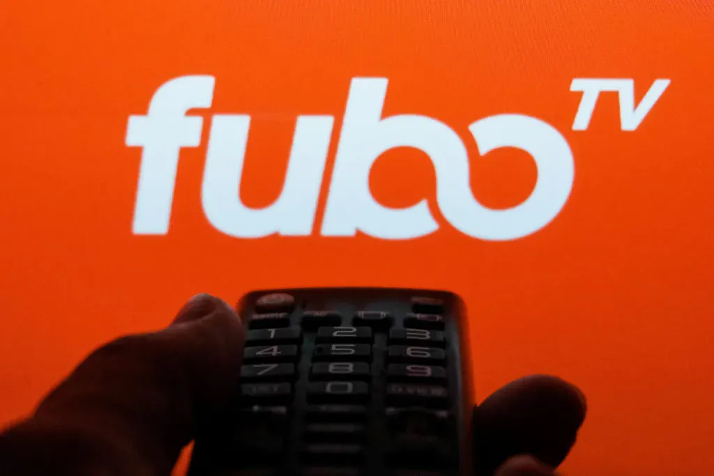 TV remote control is seen with fuboTV logo displayed on a screen in this illustration photo.