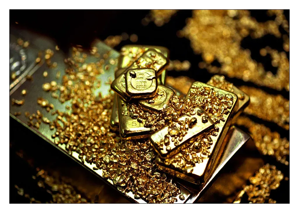 A selection of gold bars and gold flakes.