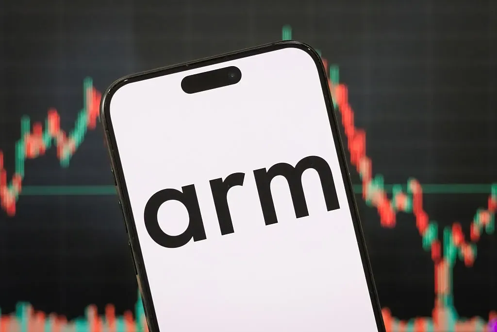 In this photo illustration, the logo of Arm Holdings plc is displayed on a smartphone screen, with a stock market chart in the background.