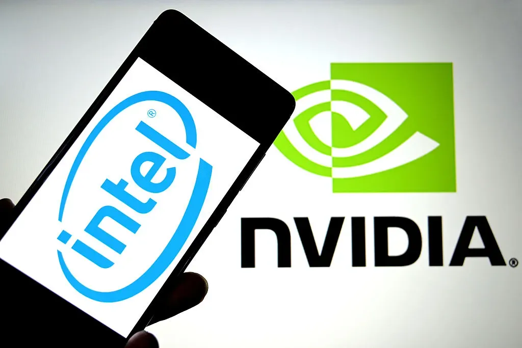 In this photo illustration, an Intel logo is seen displayed on a smartphone and a Nvidia logo in the background.