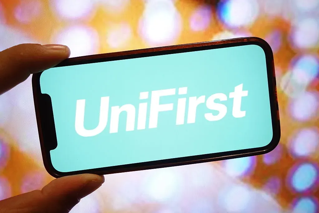 In this photo illustration, the UniFirst company logo is seen displayed on a smartphone screen.