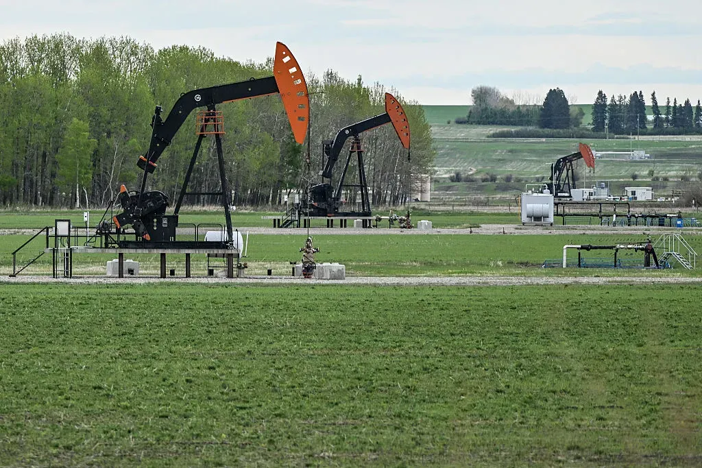 Oil wells seen in a field seen along Highway 27 between Sundre and Olds, in Alberta, Canada.