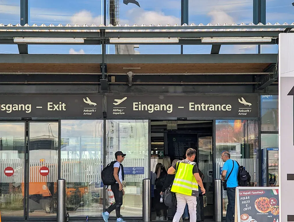 People enter and exit the main terminal of Memmingen Airport in Memmingen, Swabia, Lower Allgaeu, Allgaeu, Germany, on July 12, 2025. (Photo by Michael Nguyen/NurPhoto via Getty Images)
