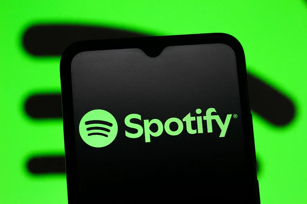 In this photo illustration, the Spotify logo is seen displayed on a smartphone screen. 