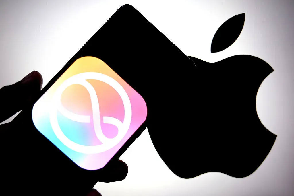 In this photo illustration, an Apple Siri logo is seen displayed on a smartphone with an Apple logo in the background.