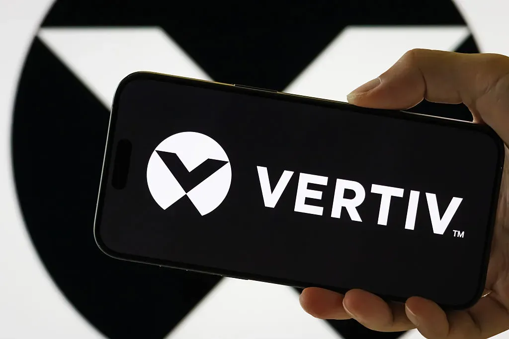 In this photo illustration, a person holds a smartphone displaying the logo of Vertiv Holdings Co.