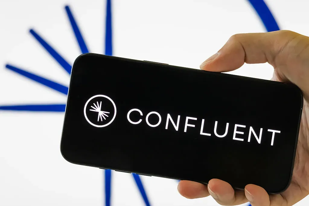 In this photo illustration, a person holds a smartphone displaying the logo of Confluent Inc.