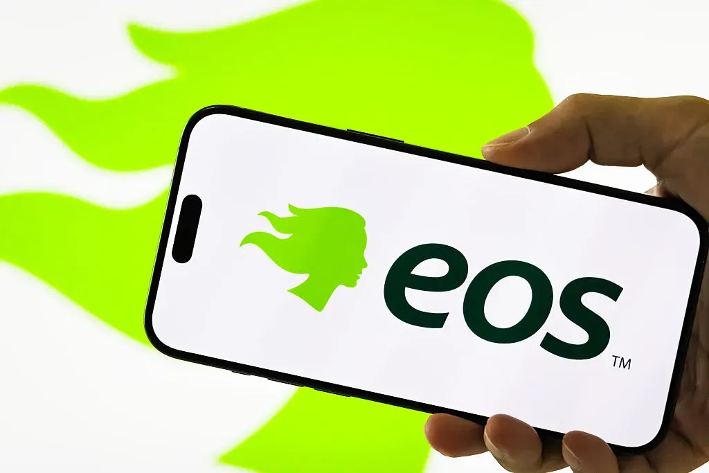 In this photo illustration, a person holds a smartphone displaying the logo of Eos Energy Enterprises Inc.