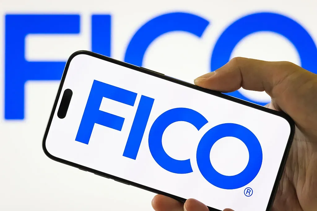 In this photo illustration, a person holds a smartphone displaying the logo of Fair Isaac Corporation.