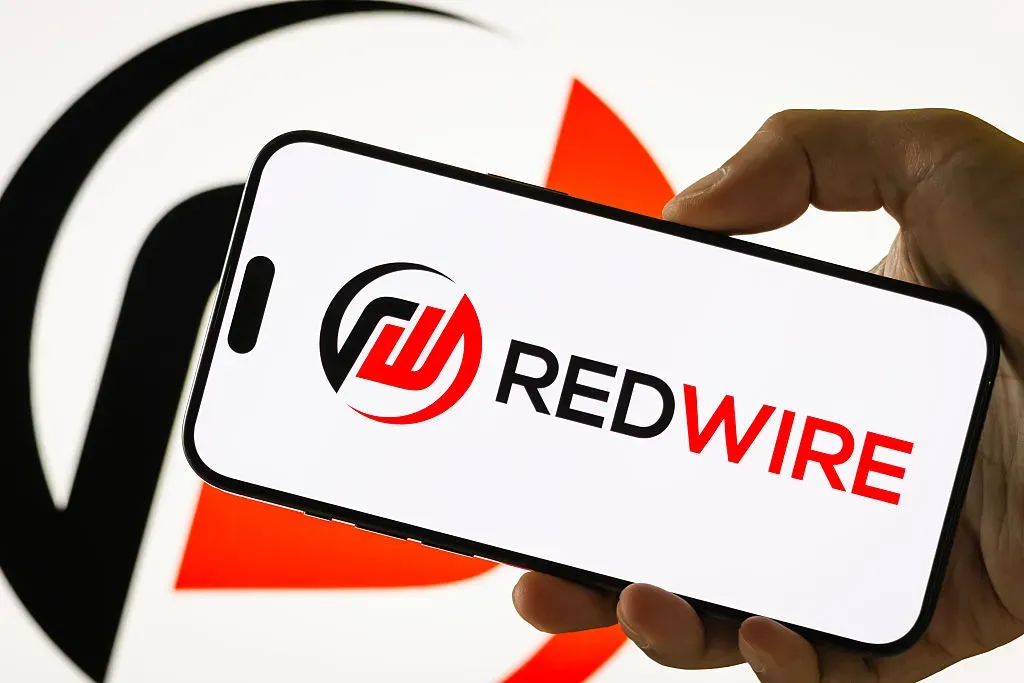 In this photo illustration, a person holds a smartphone displaying the logo of Redwire Corporation.