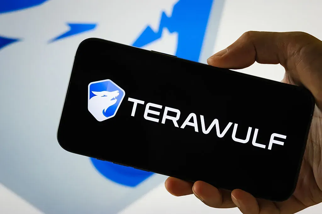 In this photo illustration, a person holds a smartphone displaying the logo of TeraWulf Inc.