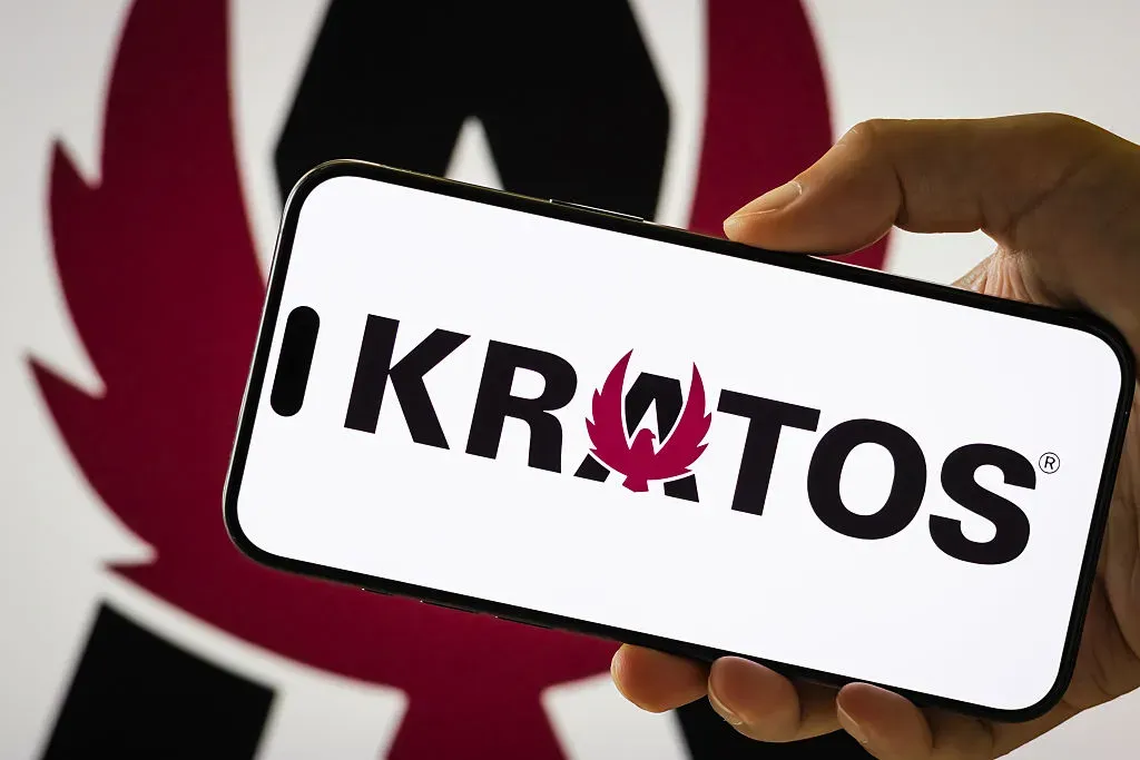  In this photo illustration, a person holds a smartphone displaying the logo of Kratos Defense & Security Solutions Inc. 