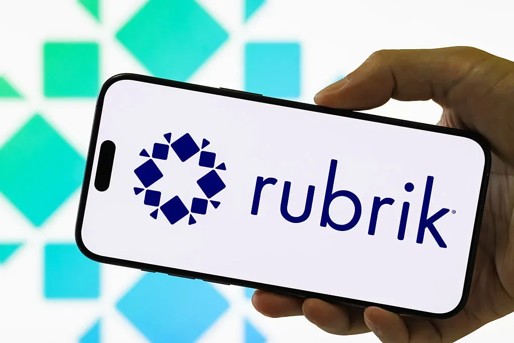 In this photo illustration, a smartphone held in a hand shows the logo of Rubrik Inc.