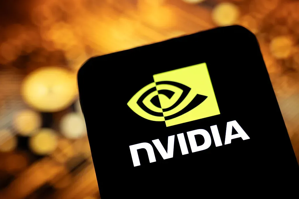 In this photographic illustration, the Nvidia logo appears on a smartphone with an illustration of printed circuit boards in the background.