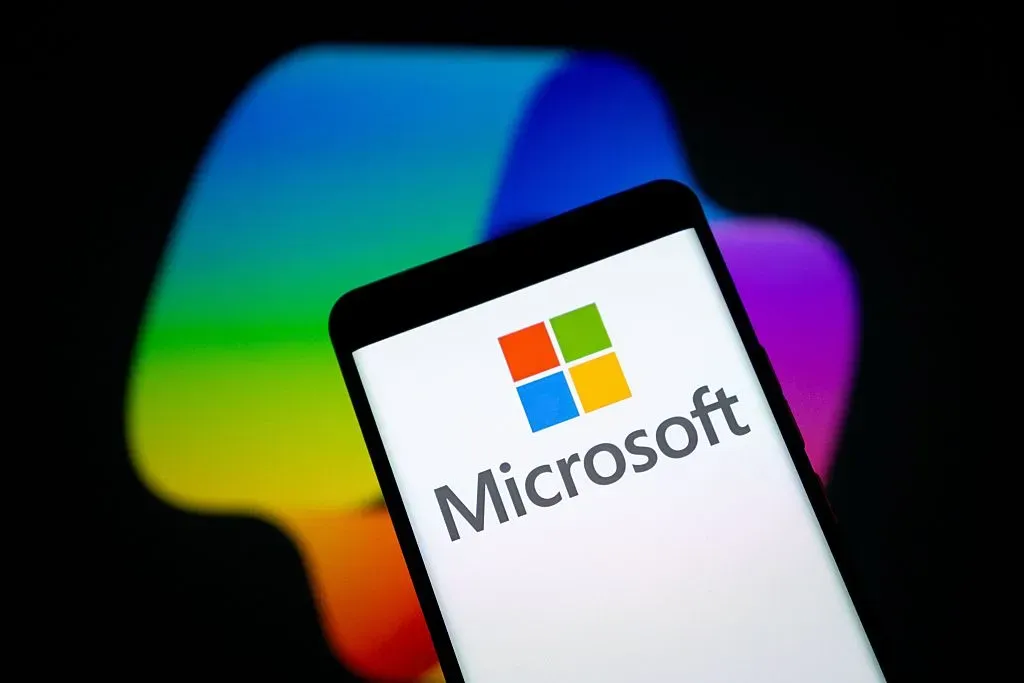 Screens show the logo of Microsoft and its AI service Copilot. 