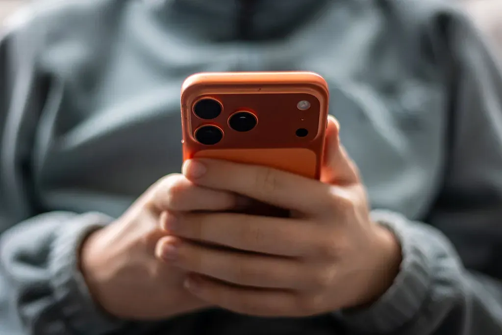 In this photo illustration a 15-year-old boy looks at a iPhone screen displaying various social media apps.