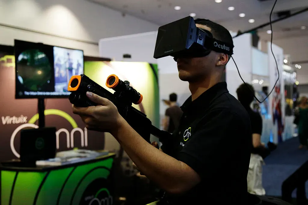 An E3 attendee tries out the Virtuix Oculus Rift and Omni Treadmill.