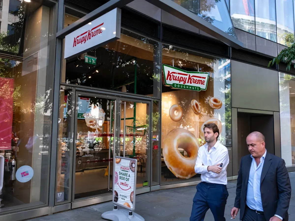 People walk outside a Krispy Kreme store in London. (photo by Mike Kemp/In Pictures via Getty Images)