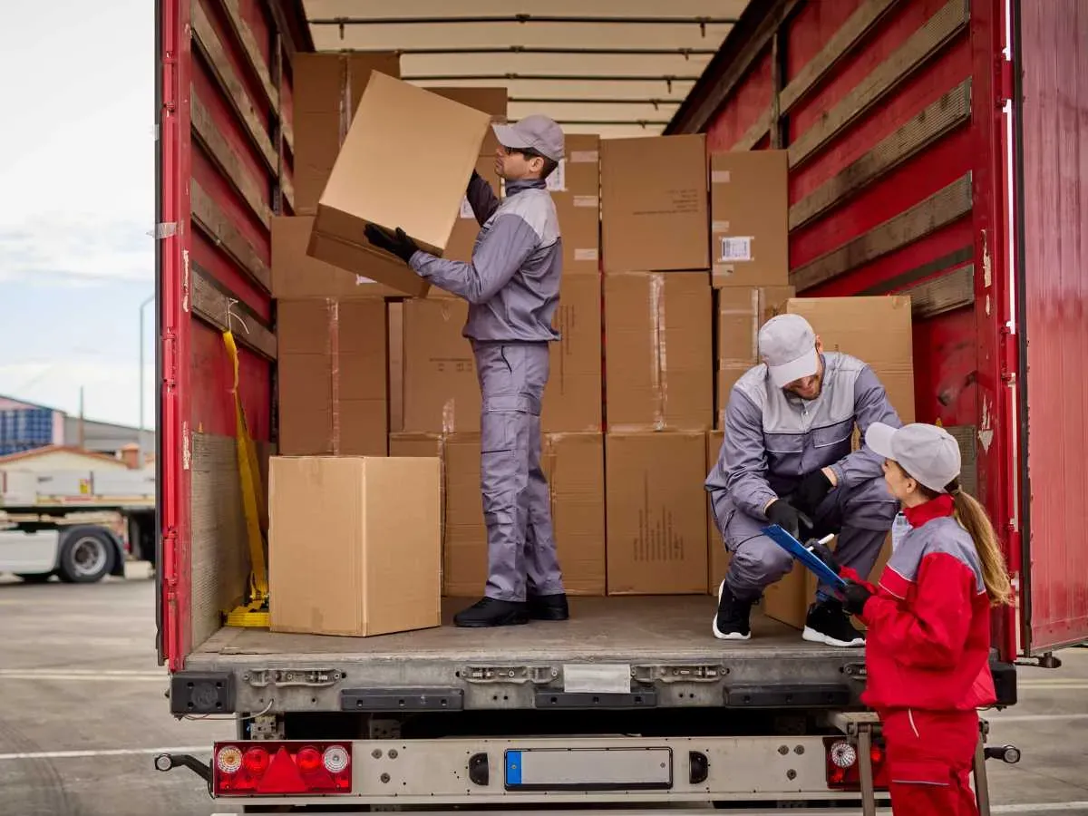 Woman receiving delivery, signing a clipboard.