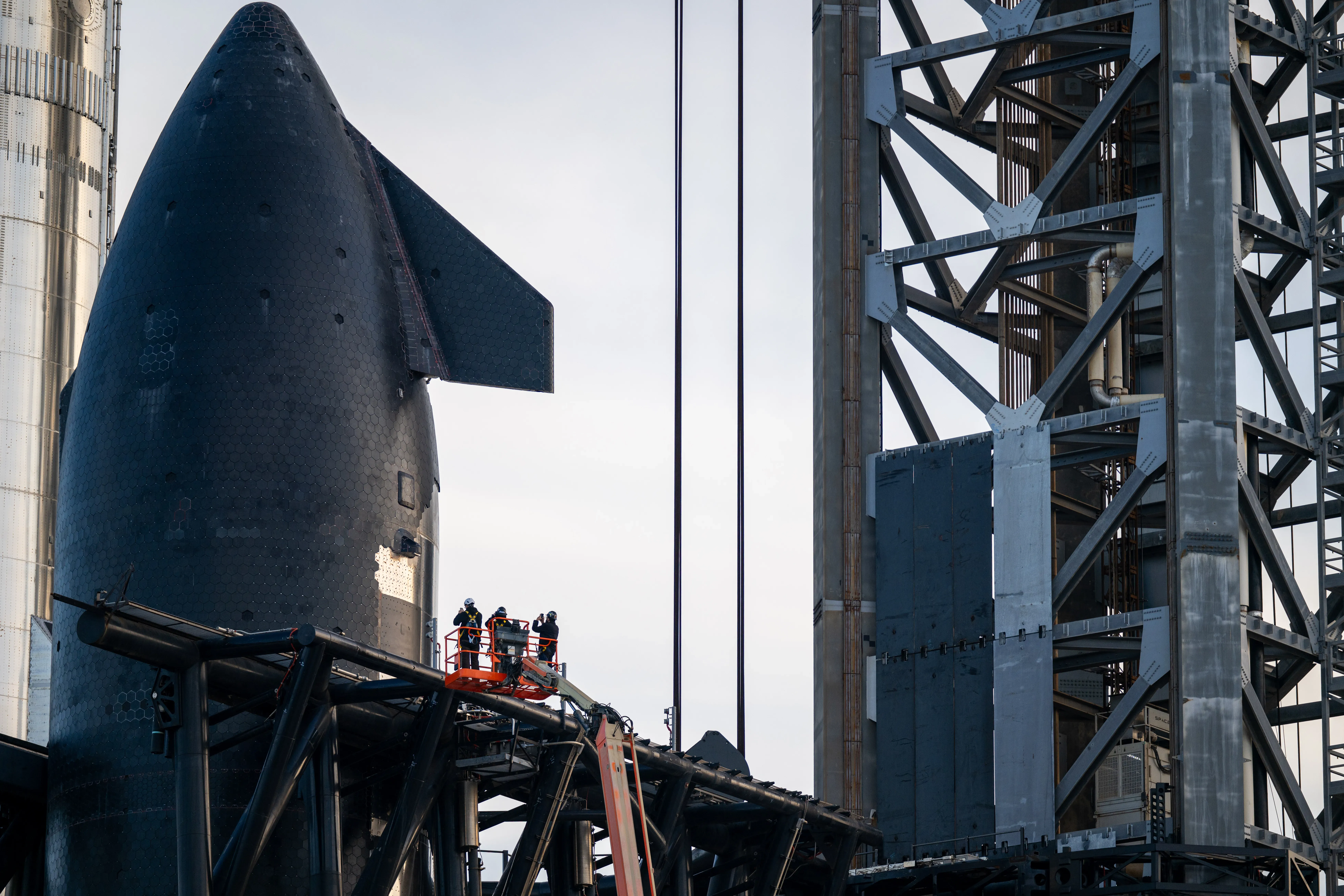 Employees survey SpaceX Starship Flight 8 near the Orbital Launch Pad A ahead of its launch at Boca Chica beach on March 03, 2025 in Boca Chica Beach, Texas.