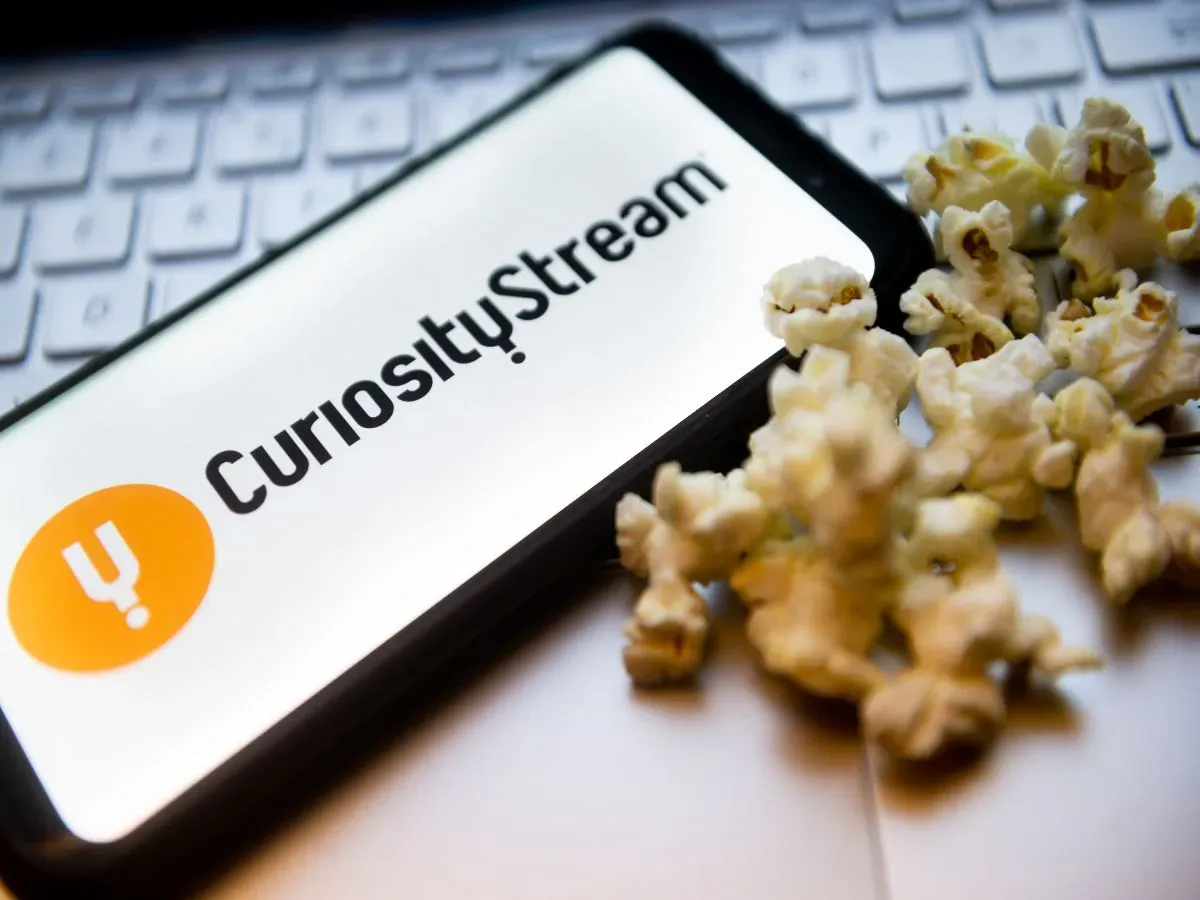  In this photo illustration a CuriosityStream logo seen displayed on a smartphone with popcorns and laptop keyboard in the background.