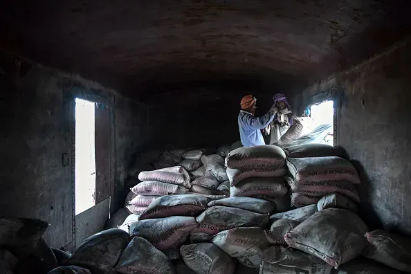 Labourers unload cement bags from freight trains at the railway junction. (Photo by Saqib Majeed/SOPA Images/LightRocket via Getty Images)
