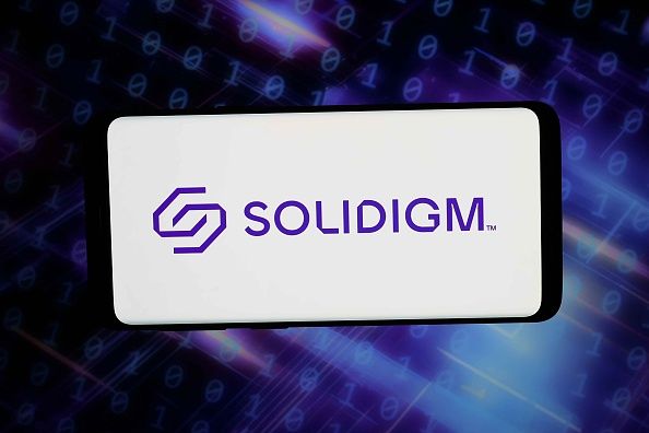 In this photo illustration, the logo of US flash memory company Solidigm is seen displayed on a smartphone in front of ab abstract background on computer screen. (Photo Illustration by Timon Schneider/SOPA Images/LightRocket via Getty Images)