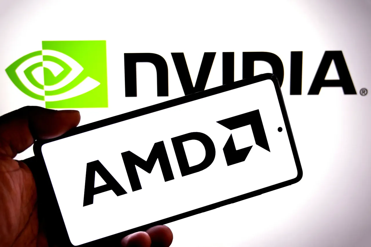 In this photo illustration, an AMD logo is seen displayed on a smartphone with a Nvidia logo in the background. 