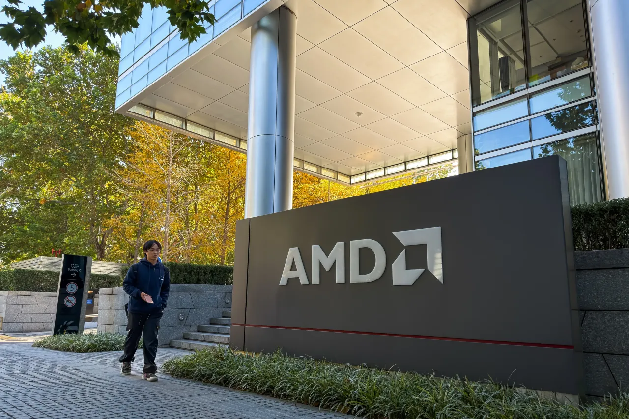 A pedestrian walks past the AMD logo outside a commercial building that houses the company's Beijing office on November 11, 2025, in Beijing, China.