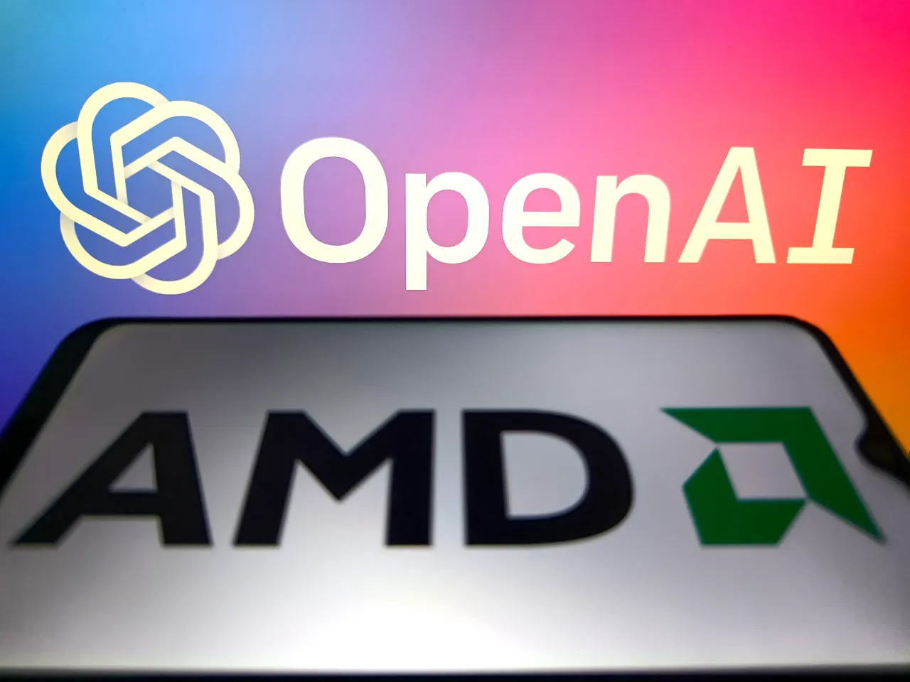 An illustration photo shows AMD logo in a smartphone with the OpenAI logo in the background in Suqian, Jiangsu Province, China on October 7, 2025. (Photo credit should read CFOTO/Future Publishing via Getty Images)