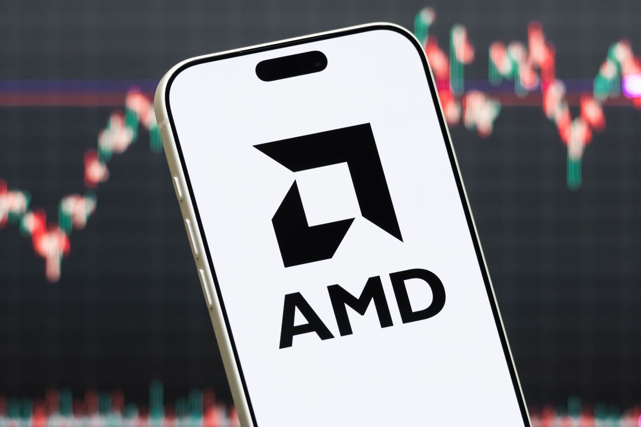 A smartphone displays the logo of Advanced Micro Devices(AMD) in front of a screen showing the company’s stock market chart. (Photo illustration by Cheng Xin/Getty Images)