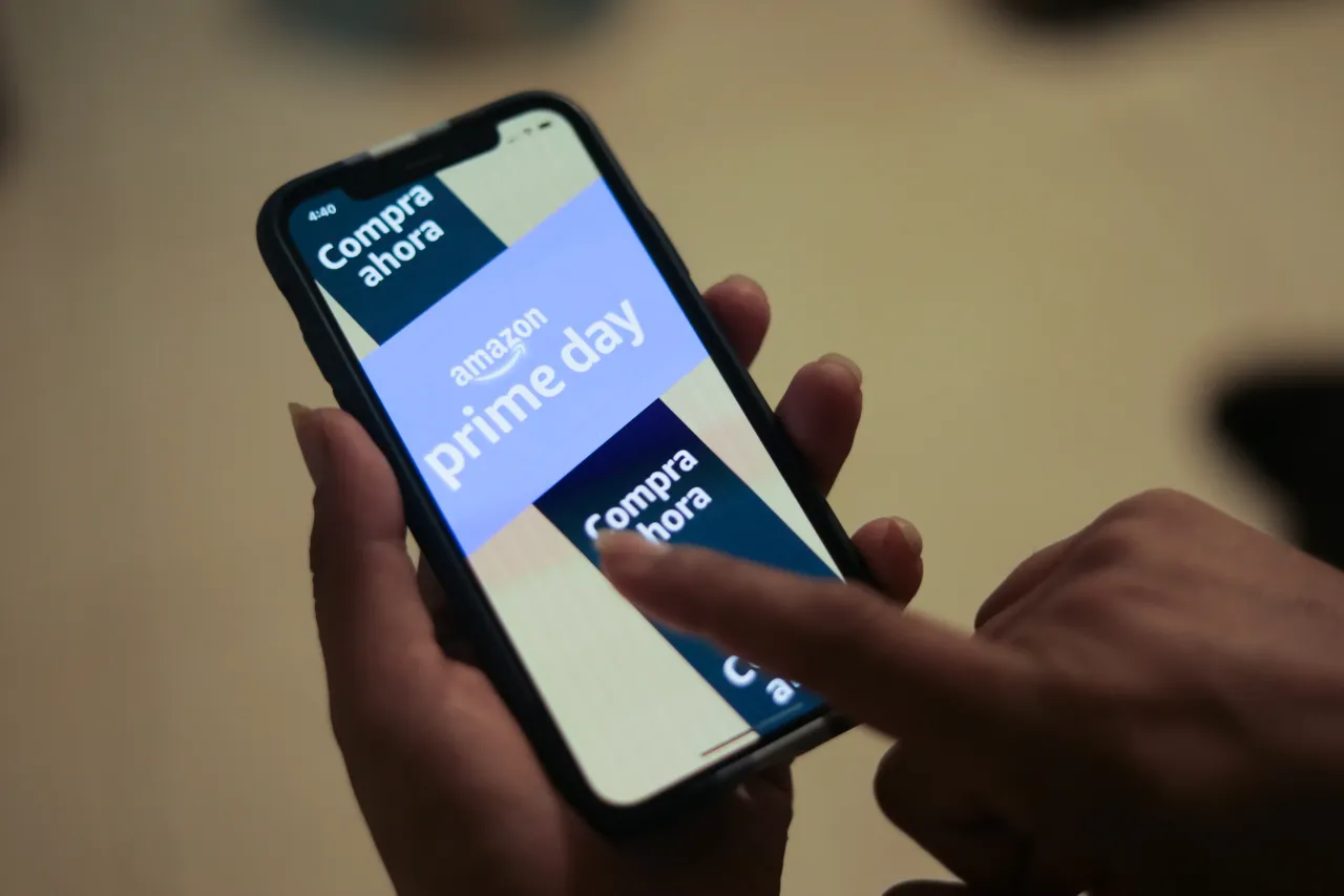 In this photo illustration Amazon advertising is seen on a cell phone that offering promotions available on its official website.