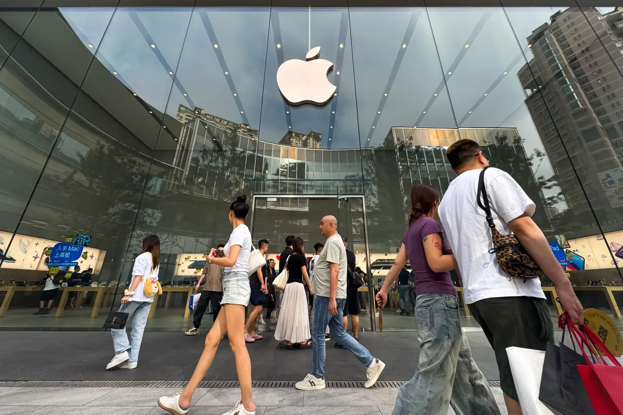 Pedestrians walk past an Apple retail store with the company's logo displayed on the glass facade on September 18, 2025, in Chongqing, China. 