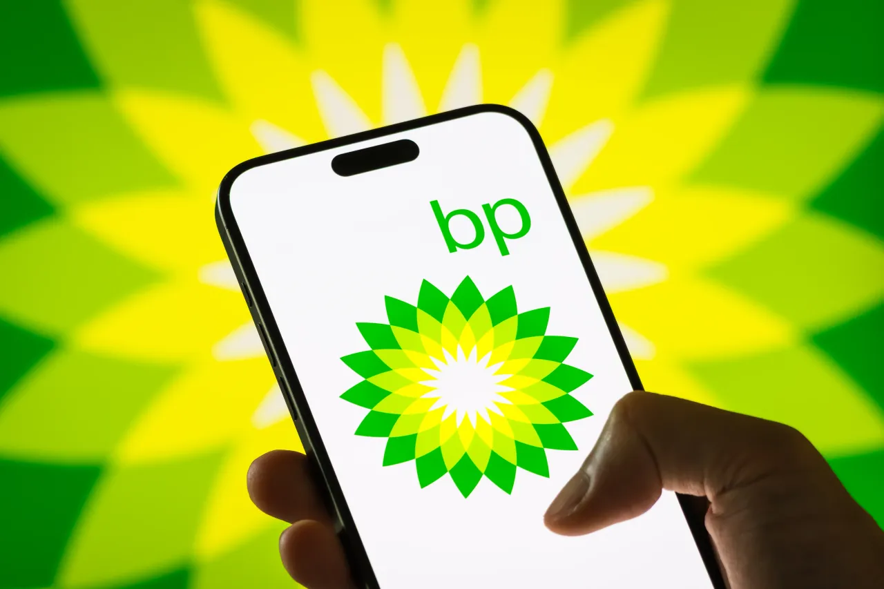 In this photo illustration, a person holds a smartphone displaying the logo of BP plc.