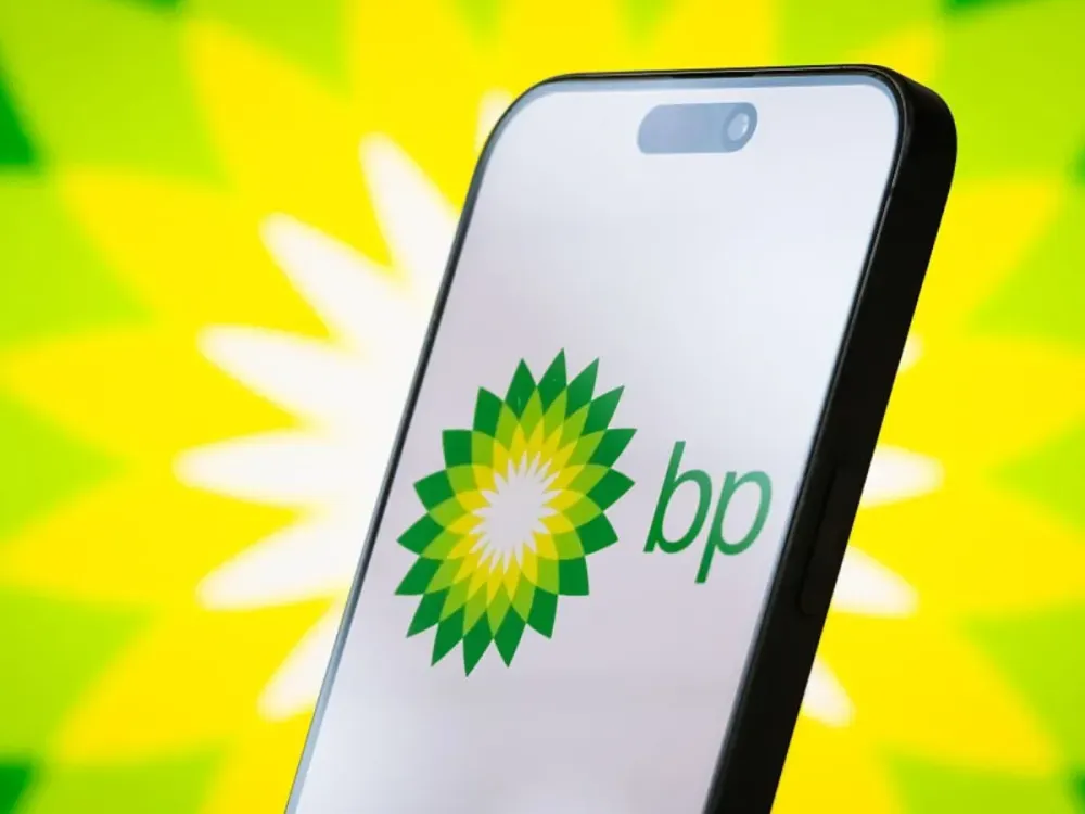In this photo illustration, the logo of BP p.l.c. is displayed on a smartphone screen, with the company's signature green and yellow helios emblem visible in the background, on April 23, 2025.