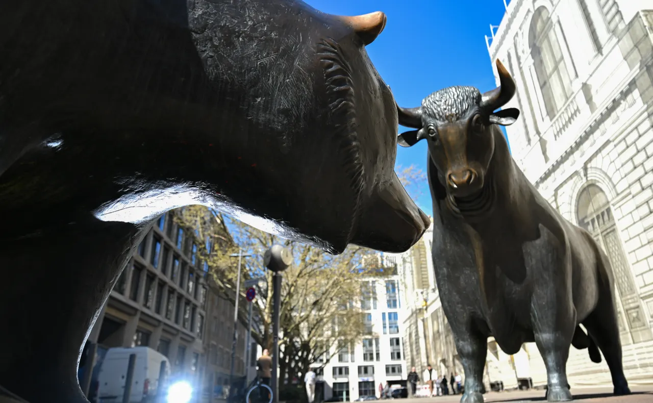 08 April 2025, Hesse, Frankfurt/Main: The bronze figures of the bull (r) and bear, symbols of the upswing and downswing on the stock market, stand on the square in front of the stock exchange.  