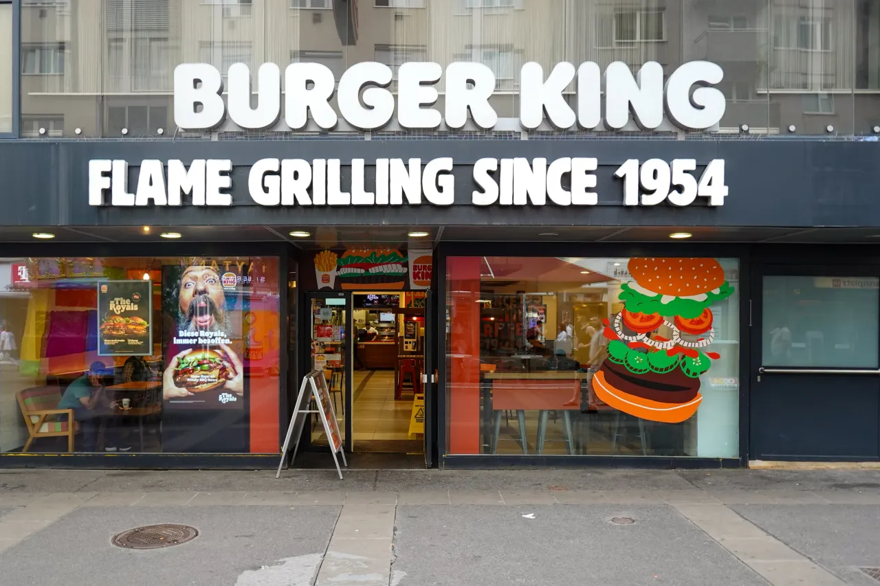 A Burger King restaurant with the slogan ''Flame Grilling Since 1954'' is seen in Vienna, Austria, on June 7, 2025. Promotional posters and interior seating are visible through the storefront windows.