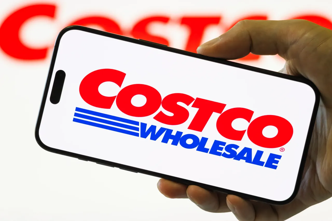  In this photo illustration, a smartphone held in a hand shows the logo of Costco Wholesale Corp.