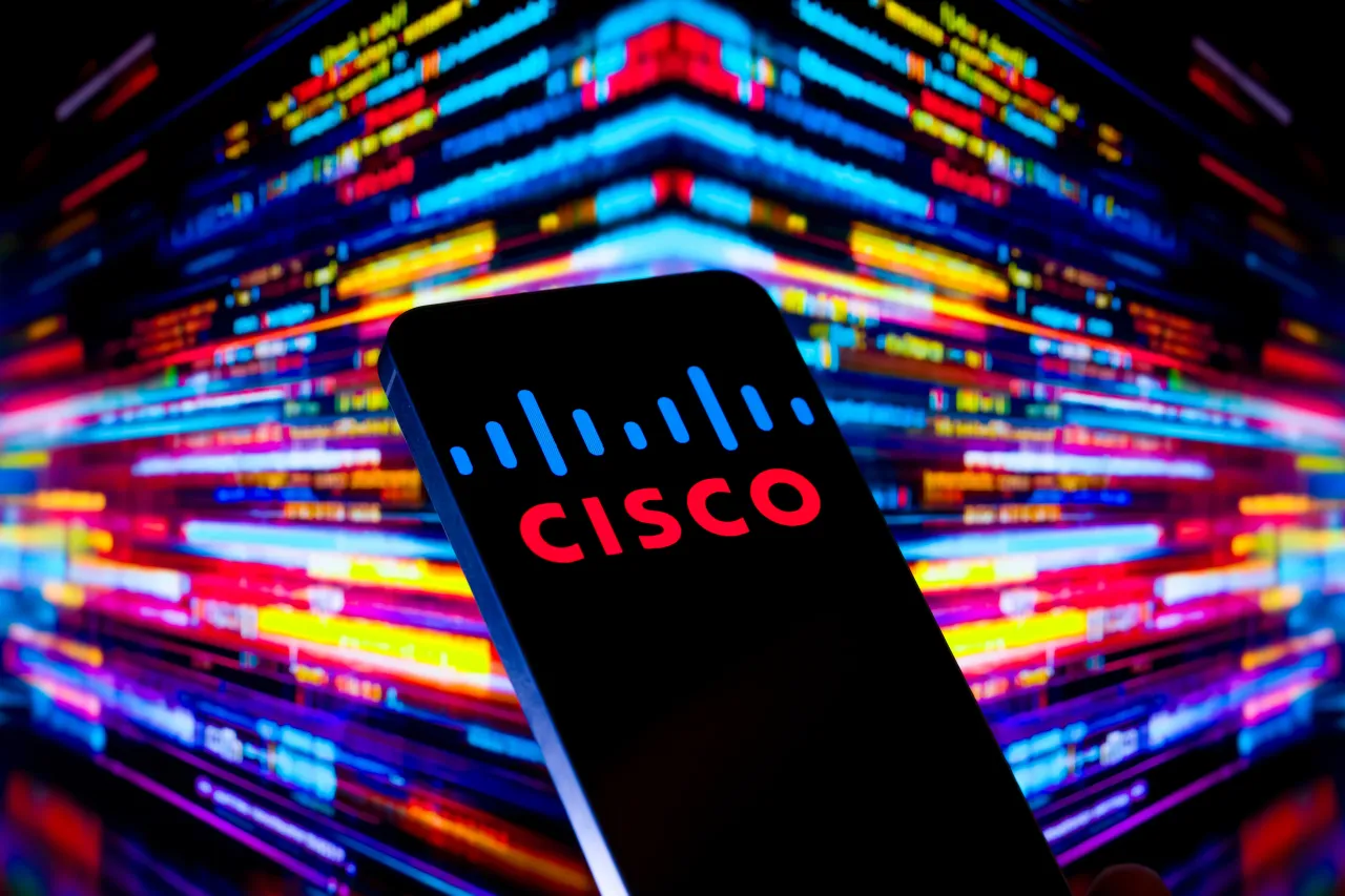 Cisco logo is displayed on a mobile phone with the digital screen visible in the background in this photo illustration in Brussels, Belgium, on November 11, 2025. 