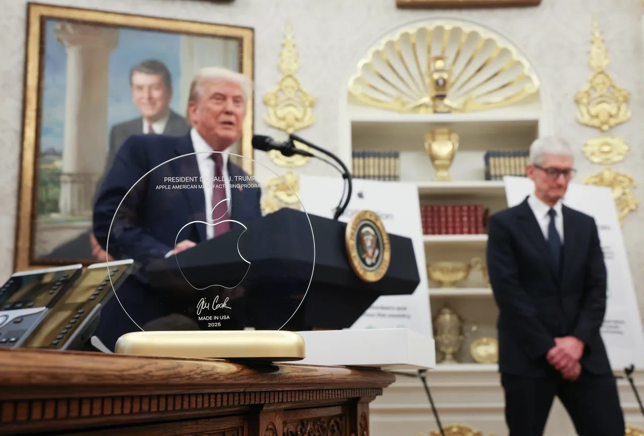 U.S. President Donald Trump speaks behind an engraved glass disc presented to him by Apple CEO Tim Cook during an event in the Oval Office of the White House on August 6, 2025, in Washington, DC. 