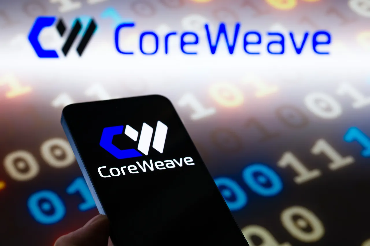 CoreWeave logo is displayed on a mobile phone, with the company's branding visible in the background, in this photo illustration in Brussels, Belgium, on November 10, 2025. 