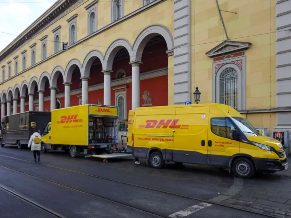 Two DHL delivery vans deliver parcels in Maximilianstrasse in Munich, Germany, on February 20, 2025 (Photo by Michael Nguyen/NurPhoto via Getty Images).