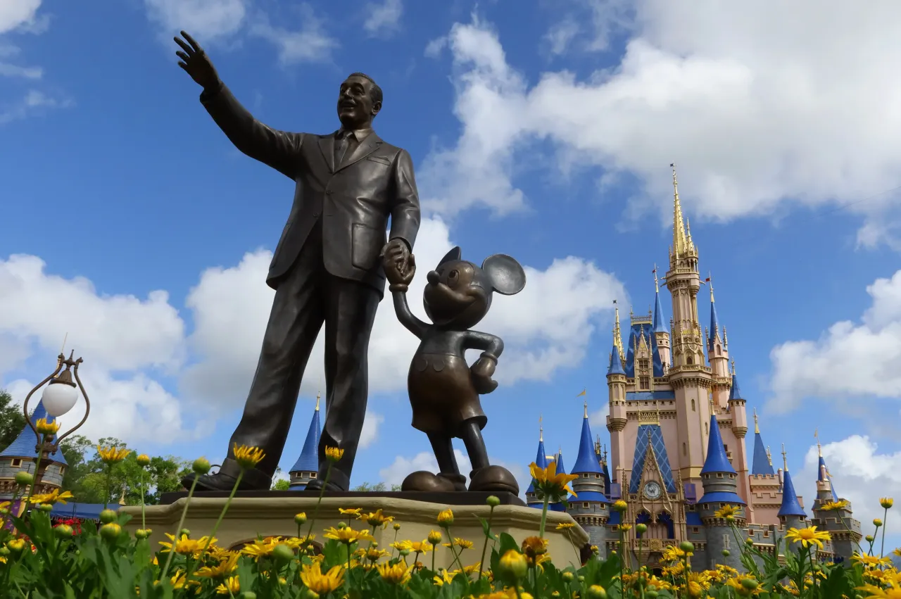 A statue of Walt Disney and Mickey Mouse stands in a garden in front of Cinderella's Castle at the Magic Kingdom Park at Walt Disney World on April 3, 2025, in Orlando, Florida.