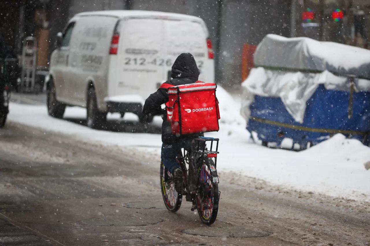 A food delivery guy with bicycle is seen as snowfall blankets the Times Square in New York City, United States as massive snow storm hits the east coast on February 18, 2021.