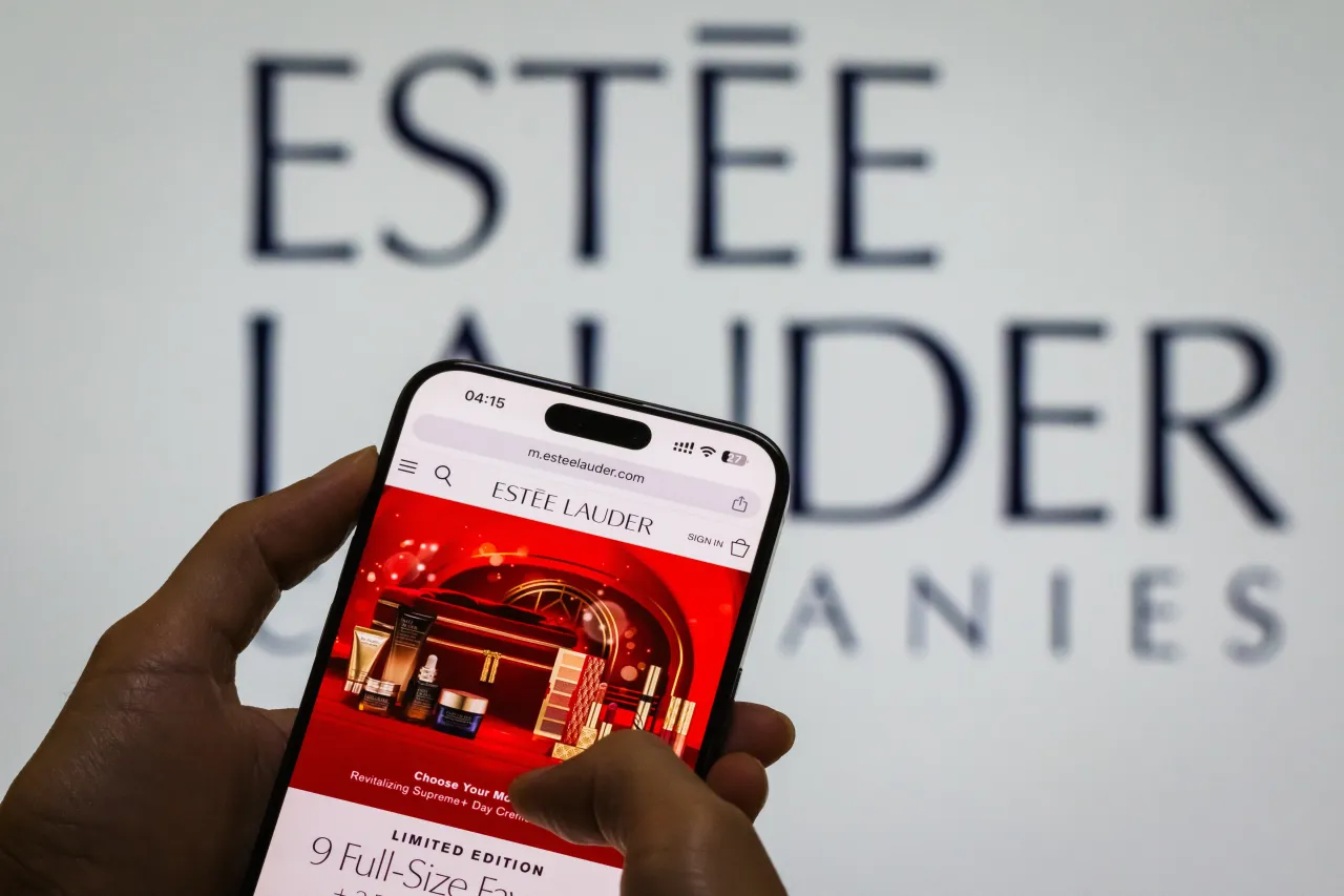 The Estée Lauder webpage is displayed on a smartphone in front of the The Estée Lauder Companies Inc. logo on October 31, 2024 in Chongqing, China.