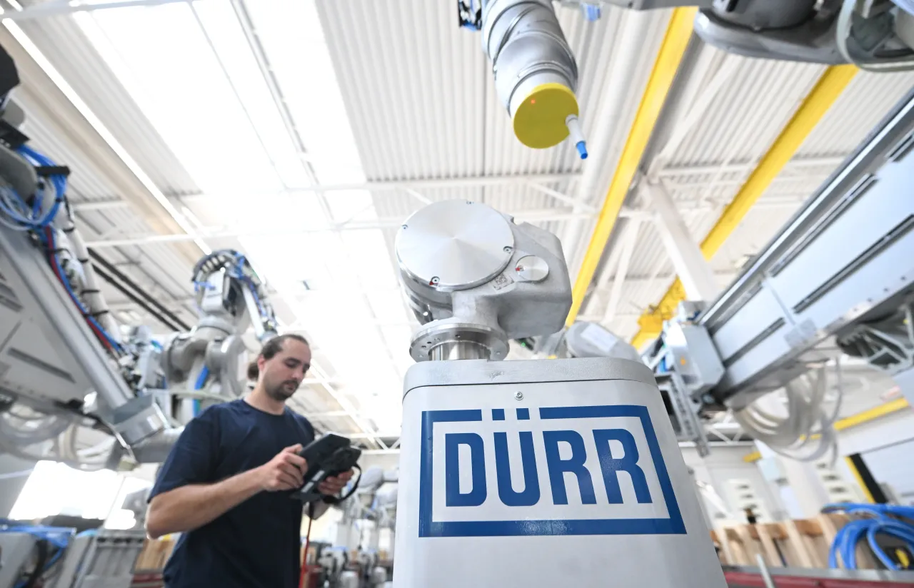 A worker from the mechanical engineering company Dürr assembles a robot arm for a vehicle painting system at its headquarters. 