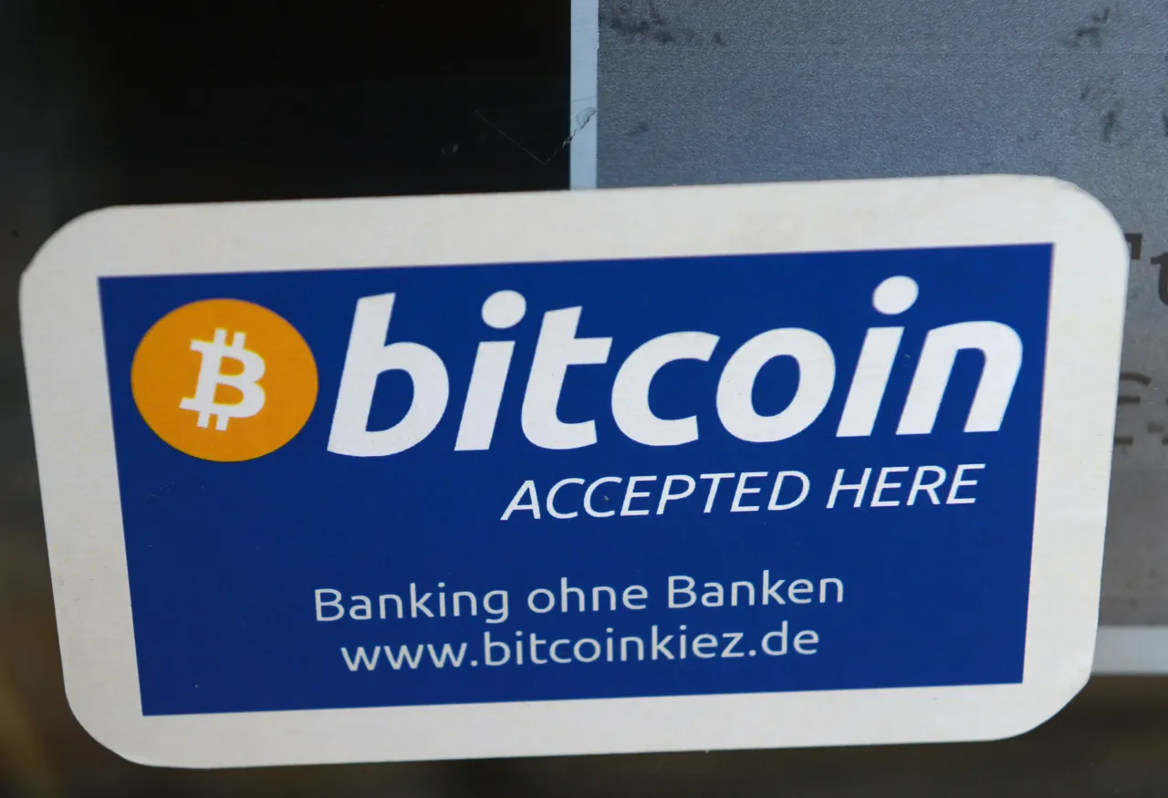 Bitcoin accepted here is posted at the entrance to a bar in Berlin-Kreuzberg, Germany, 24 May 2013. (Photo by Jens Kalaene/picture alliance via Getty Images)