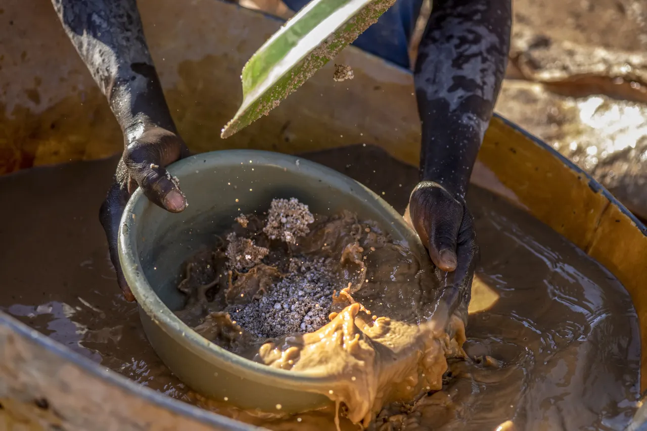 An artisanal miner sifts through crushed ore powder for gold particles at a small-scale gold mine in Zimbabwe. Photographer: Cynthia R Matonhodze/Bloomberg via Getty Images